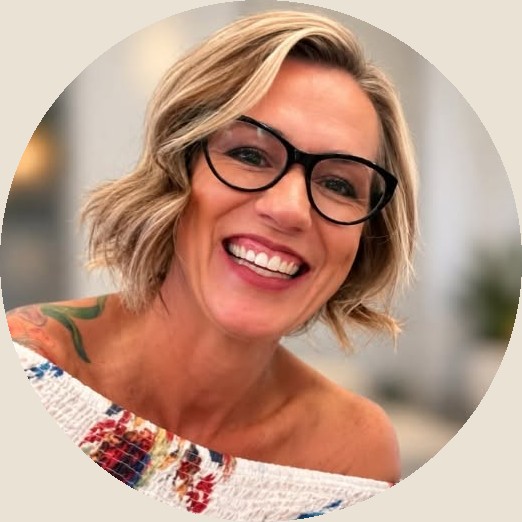 Jill McCracken, smiling, in glasses and a floral top